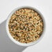 A white bowl filled with everything bagel seasoning, containing a mix of sesame seeds, poppy seeds, dried garlic, dried onion, and salt.