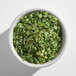 A small white bowl filled with dried chives.