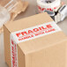 A box with Tape Logic white "Fragile / Handle With Care" tape on it.