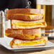 A stack of grilled cheese sandwiches made with Stockeld Dreamery MELT vegan cheddar cheese.