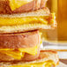 A stack of grilled cheese sandwiches made with Stockeld Dreamery MELT vegan cheddar slices.