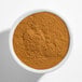 A white bowl filled with ground cinnamon powder.