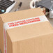 A brown Tape Logic carton with a label that says "Mixed Merchandise" with tape on it.