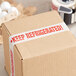 A white box with "Keep Refrigerated" on it sealed with Tape Logic "Keep Refrigerated" tape.