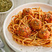 A plate of spaghetti and meatballs with dried parsley on a table in an Italian restaurant.