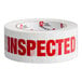 A white Tape Logic roll of tape with red text reading "Inspected"