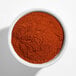 A white bowl filled with finely ground red smoked paprika powder.