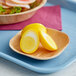A wooden spoon with sliced yellow pickled hard boiled eggs on it.