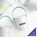 A group of white Howw Manufacturing plastic drink buckets with teal handles.