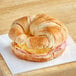 A Day 'N Night Bites ham, egg, and cheese croissant sandwich on a cutting board.