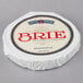 A round white wheel of Eiffel Tower Brie cheese with a blue and red label.