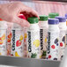 A hand holding a Chobani Pina Colada Greek yogurt drink bottle.