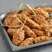 A tray of Simply Cuisine Chicken Waffle Skewers on a gray surface.