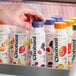 A hand holding a plastic bottle of Chobani Low-Fat Mixed Berry Greek Yogurt Drink with a purple label.