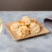 A Elite Global Solutions Green Square Paper Plate with coconut macaroons on it on an outdoor patio table.