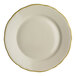 A close-up of a Homer Laughlin white china plate with scalloped edges and gold trim.