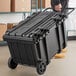 A man pushing a large black Tough Box rolling tool chest.