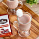 A glass cup of Cocoa Classics Chocolate Supreme hot chocolate with a marshmallow on top.