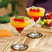 Two glasses of orange and red Primor Mango Puree drinks with cherries and mint garnish.