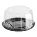 A clear plastic container with a clear scalloped lid over a black plastic cake plate.