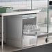 A Noble Warewashing undercounter dishwasher in a school kitchen.
