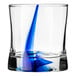 A Libbey Rocks glass with blue liquid swirled in it.