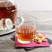 A Libbey Winchester rocks glass filled with liquid on a napkin with peanuts.