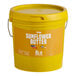 A yellow Vor sunflower butter pail with a lid.