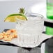 A Libbey Everest rocks glass with ice and a lime wedge.