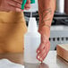 A person's hand pouring liquid into a white plastic Lavex bottle.