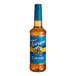 A 750 mL plastic bottle of Torani Sugar-Free Caramel Flavoring Syrup with a blue label.