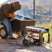 A man welding a metal object to a Tomahawk portable generator.