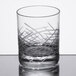 A close up of a Reserve by Libbey Crosshatch Rocks glass on a table.