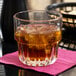 A Libbey Everest stackable rocks glass with a drink and ice on a table.