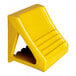 A yellow cast ductile iron wheel chock with a handle.