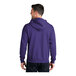 A man wearing a purple Port & Company full-zip hoodie with a white background.