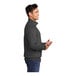 A man wearing a dark heather grey Port & Company 1/4 zip fleece pullover.