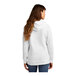 A woman wearing a white Port & Company fleece pullover hoodie.