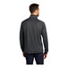 A man wearing an iron gray and black Port Authority quarter-zip pullover sweater.