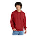 A man wearing a red District sweatshirt with a hood.