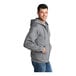 A person wearing a Port & Company Core Fleece full-zip hoodie in athletic heather.