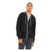 A man wearing a black zip up Bella + Canvas hoodie.