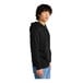 A man wearing a black District sweatshirt with a zipper.