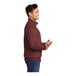A man wearing a maroon Port & Company quarter-zip pullover sweatshirt.
