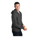 A man wearing a charcoal Port & Company full-zip hoodie.