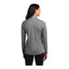 A woman wearing a Sport-Tek dark grey quarter-zip pullover sweatshirt.