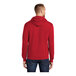 A man wearing a red Port & Company fleece pullover hoodie with a hood.