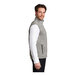 A man wearing a gray Port Authority fleece sweater vest.