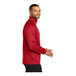 A man wearing a Port Authority red quarter-zip sweatshirt.
