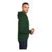 A person wearing a dark green Port & Company Core Fleece pullover hoodie.